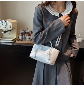 Détail du sac cabas dégradé bleu avec texte porté par un mannequin en robe grise