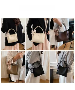 Close-up of leather crossbody buckets with silk scarves in four elegant colors