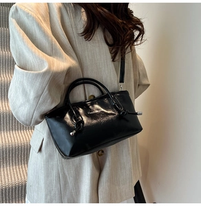 Détail du sac cabas en cuir noir brillant avec imprimé fashion bag et nœud décoratif