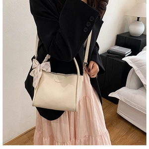 Detail of off-white lychee texture leather bag with a stylish checkered silk scarf handle