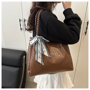 Detail view of large dark brown woven tote bag with a decorative France Paris silk scarf