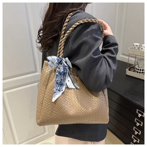 Detail of khaki woven leather tote bag with silk scarf on a commuter style model