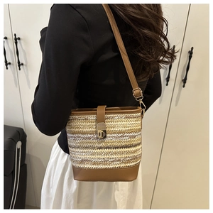 Detailed texture of woven color-block bucket bag with leather trim and metal lock