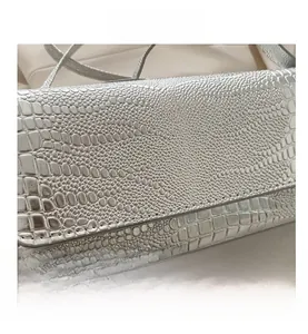 Detailed close-up of metallic silver faux crocodile texture on a stylish handbag