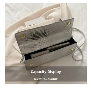 Macro view of silver crocodile pattern shoulder bag showing spacious interior capacity