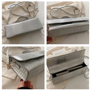 Macro view of silver crocodile pattern handbag with magnetic closure and interior space