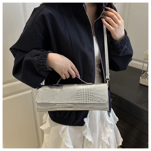 Silver crocodile pattern handbag with metallic finish worn as a stylish crossbody bag