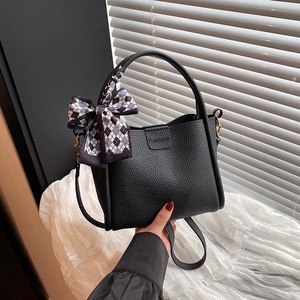 Elegant black lychee textured handbag with silk scarf bow and crossbody strap