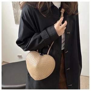 Vue détaillée du sac à bandoulière en forme de cœur avec motif crocodile et zip métallique