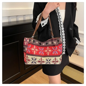 Detail of colorful ethnic geometric embroidery on tapestry tote bag with brown leather strap