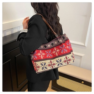 Close-up of ethnic jacquard pattern and brown leather strap on a versatile tote bag