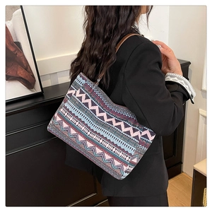 Macro shot of ethnic geometric pattern weaving and brown leather strap on tote bag