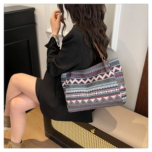 Close-up of bohemian geometric pattern tote with brown leather strap on model