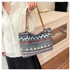 Side view of bohemian square tote bag with colorful geometric patterns and leather handles