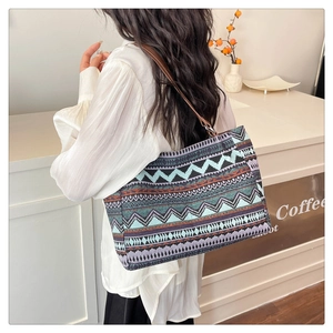 Close-up of geometric ethnic tote bag with brown leather strap worn by a model