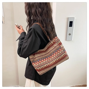 Close-up of ethnic tote bag featuring geometric patterns and brown leather straps