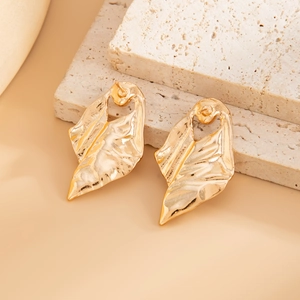 Detailed view of golden leaf earrings with liquid metal texture on natural stones