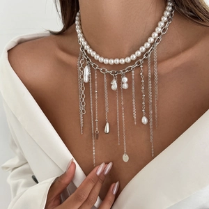 Detail view of multi-layer necklace with white pearls, silver chains and heart tassels