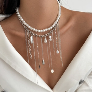 Close-up of double-layer necklace with pearls and silver chain on white suit