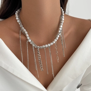 Detail of layered pearl chain necklace with shimmering rhinestone tassels on a model