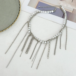 Macro detail of layered pearl necklace with silver-tone tassel chains and crystal accents