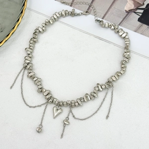 Detailed view of silver heart pendant necklace with irregular beads and fringe chains