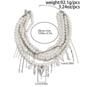 Detailed view of multilayered faux pearl necklace with silver heart and cross pendants