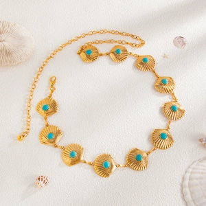 Close-up of golden scallop waist chain with turquoise beads and shell decor