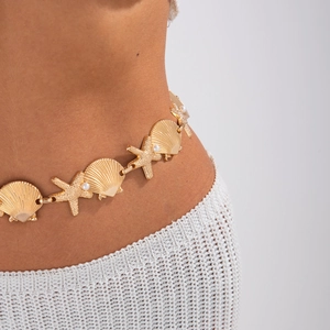 Detailed shot of golden waist chain with starfish, seashells and white pearl decor
