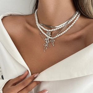 Ensemble de colliers superposés argentés avec nœuds et perles sur mannequin