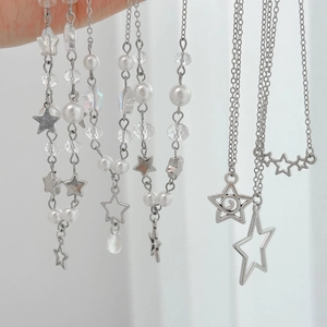 Détail des pendentifs étoiles argentées avec perles blanches et perles facettées de colliers