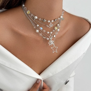 Collier multicouche avec pendentif étoile, perles blanches et cristaux porté par un mannequin