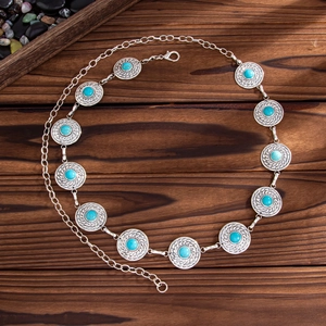Bohemian silver metal waist chain featuring turquoise discs on dark wood background