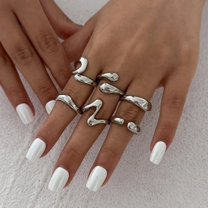 Close-up of a 6-piece silver irregular lava ring set worn on a model's hand