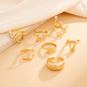 Detail view of seven-piece gold irregular geometric ring set with molten metal texture