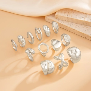 13-piece silver irregular drop and geometric open ring set on a minimal stone display