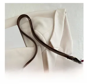 Detail view of smooth dark brown leather shoulder bag with adjustable strap and buckle