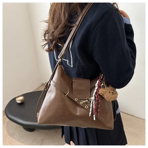 Detail of vintage brown leather tote bag with decorative strap and fashion logo embossing