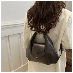Borsa tote a mezzaluna retrò marrone scuro indossata con texture in morbida pelle PU