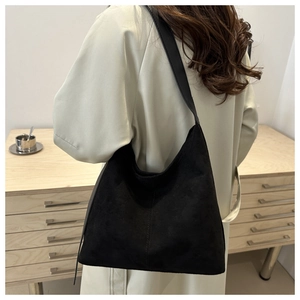 Detailed texture of black matte suede shoulder bag shown with minimalist styling