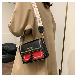 Detail of contrast color square bag with ethnic style embroidered wide shoulder strap
