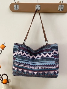 Ethnic bohemian woven tote bag with geometric patterns and brown leather shoulder straps
