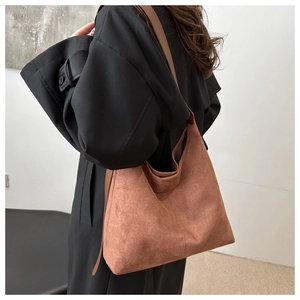 Detail view of large brown suede shoulder bag showing texture and slouchy hobo design