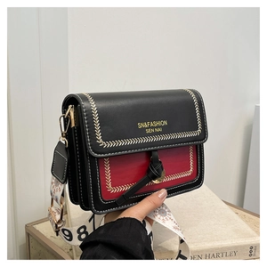 Detail of contrast color square bag showing white herringbone stitching and metal lock