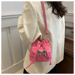 Close-up of pink nylon bucket bag with silver butterfly charm on a white blazer