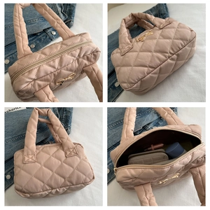 Macro view of large pink quilted tote bag with golden bow and spacious interior