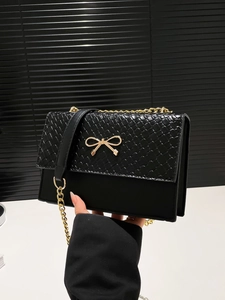 Fashionable black woven flap crossbody bag with gold bow clasp and chain strap
