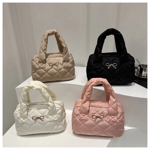 Quilted tote bags in khaki, black, white, and pink with metallic bow details