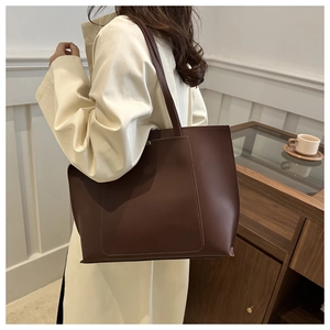 Detail of vintage brown leather tote bag showing large capacity and side pocket texture