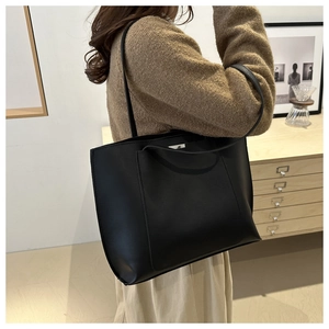 Macro detail of high-quality black leather texture on a minimalist large tote bag